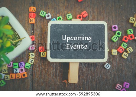 word UPCOMING EVENTS on wooden signage,artificial plant and alphabetical block concept.fade color effect