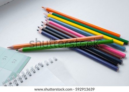 Notepad and colored pencils on a light background