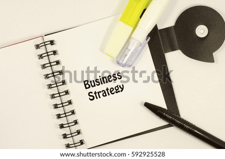 word business strategy on note pad with pen , highlighter pen and liquid paper correction pen, vintage concept image.