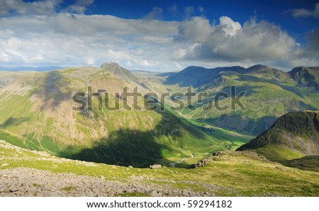 English Lake District mountains in summer. The view from Red Pike over the Mosedale Valley towards Yewbarrow, Great Gable, Kirk Fell and the Scafell Range Royalty-Free Stock Photo #59294182