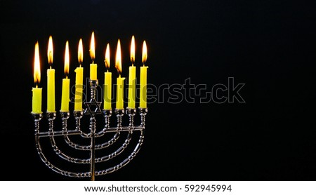 Jewish holiday hannukah low key image of jewish holiday Hanukkah with menorah traditional Candelabra and wooden dreidels spinning top . glitter overlay