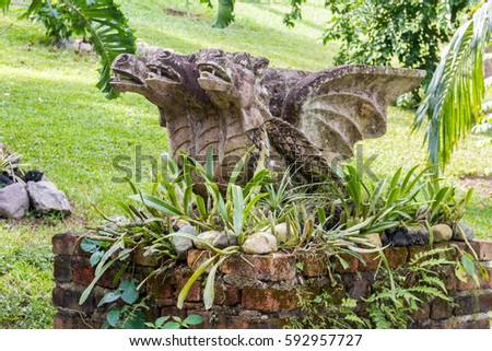 Triple head dragon statue in a flowerpot in a public park of Puerto Vallarta, México