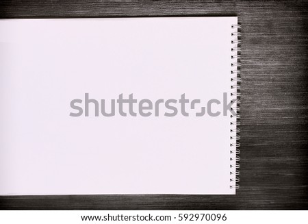 Blank notepad for sketching with pink pages on dark wooden table.