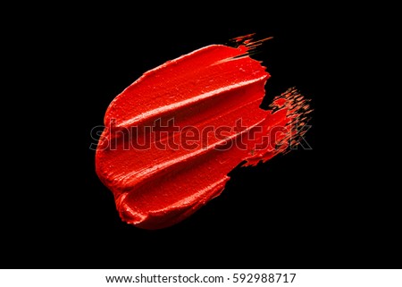 Red lipstick smudged on a black isolated background