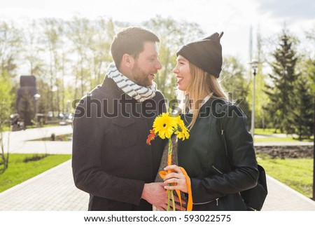 Pregnant woman with husband and bouquet of gerberas