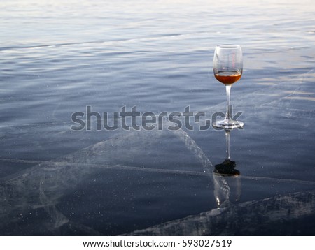 A glass of wine is on the ice.