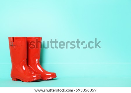 Red rubber boots on a green background Royalty-Free Stock Photo #593058059