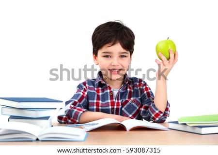Cute little boy with apple sitting at table, on white background