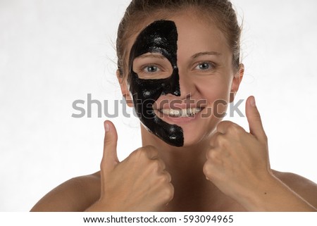 Happy beautiful girl with acne smiling on a white background in a cosmetic mask black
