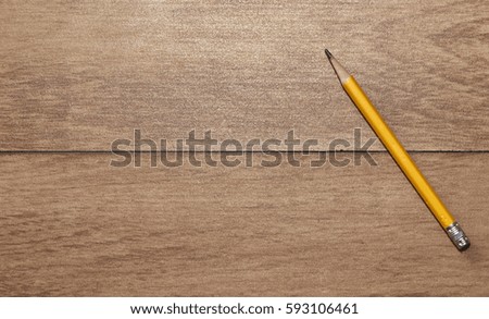 yellow pencil on wooden background, top view withcopy-space