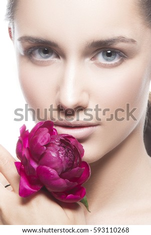 Beautiful caucasian young model girl with a flowers peony near the face. Cosmetics, beauty health and care cosmetology studio portrait