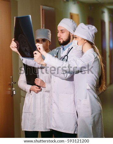 Doctors watching x-ray of patient.