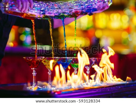 Barman show. Bartender pours alcoholic cocktails. Royalty-Free Stock Photo #593128334