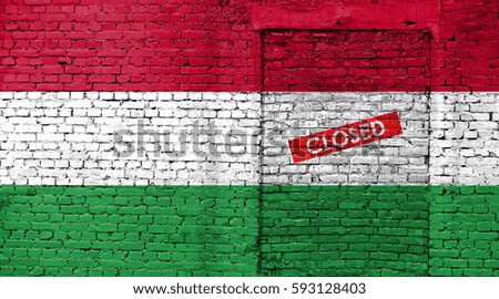 Hungary flag on brick wall with bricked door and Closed sign