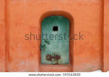 Old door in the stone wall. The walls are covered with plaster orange. The church in the city of Yaroslavl. Russia.