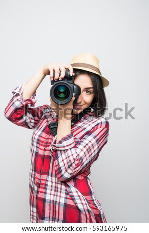 Woman traveler taking picture with camera on color background