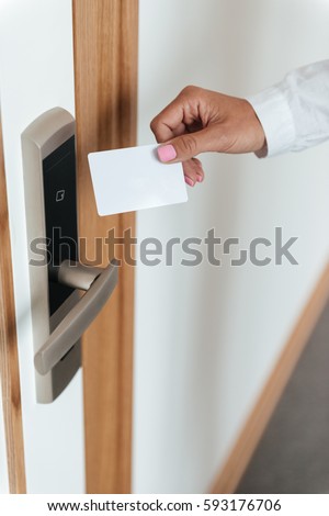 Woman hand inserting key card in electronic lock at hotel Royalty-Free Stock Photo #593176706