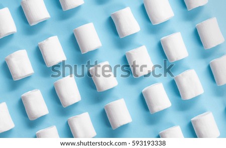 Picture of a lot of white sweeties marshmallows over blue table background.