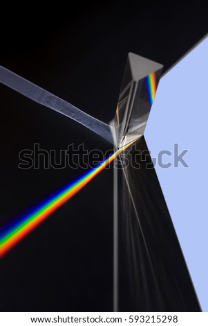 Prism splitting white light into a spectrum on a black background