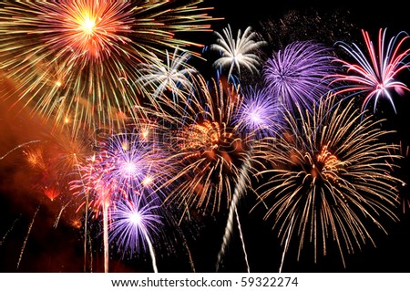 Fireworks of various colors bursting against a black background Royalty-Free Stock Photo #59322274