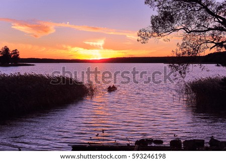 The landscape photography overlooking the lake on a sunset. A photography outdoors in the early fall in good weather with two travelers on a kayak. Tourism, travel, wild nature.