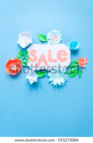 Sale frame with color paper flowers on the blue background. Flat lay. Nature concept. Cut from paper.