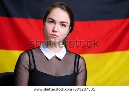 Portrait of a beautiful calm brunette girl in the background of the German flag