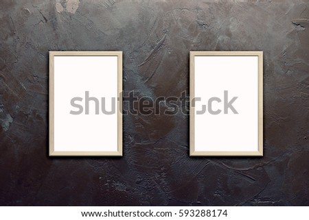 Mock up of blank posters in wooden frames on texturized brown stucco wall