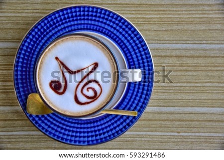 Enjoy morning top view blue cup of coffee on wooden table with nice gold spoon.