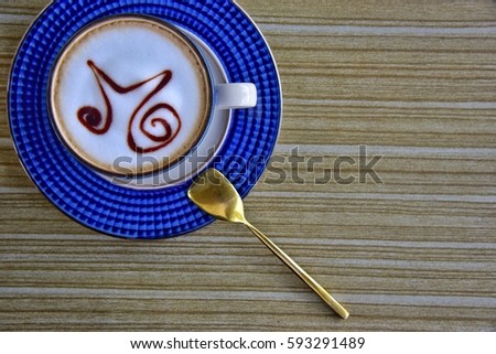 Enjoy morning top view blue cup of coffee on wooden table with nice gold spoon.