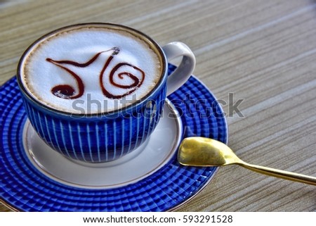 Enjoy morning blue cup of coffee on wooden table with nice gold spoon.