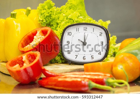 clock with fresh vegetables background