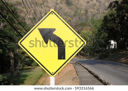 Yellow traffic sign, turn left on country road