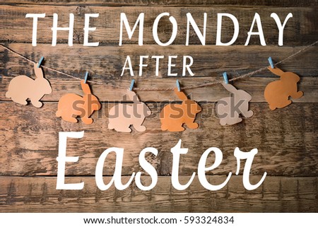 Text THE MONDAY AFTER EASTER and garland on wooden background