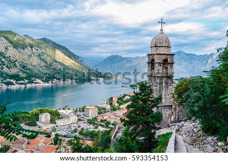 Panoramic view of town and mountains with church in foreground in Kotor, Montenegro Royalty-Free Stock Photo #593354153