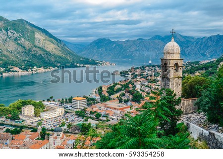 Panoramic view of town and mountains with church in foreground in Kotor, Montenegro Royalty-Free Stock Photo #593354258