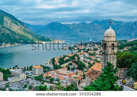 Panoramic view of town and mountains with church in foreground in Kotor, Montenegro Royalty-Free Stock Photo #593354288