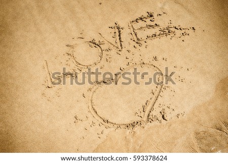 love, drawing on pure sand