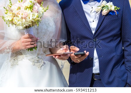 the bride and groom with mobile in hand. Modern wedding with gadgets