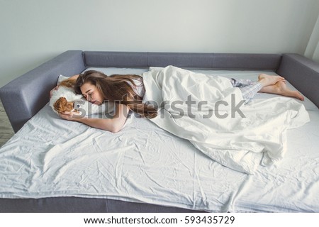 The girl with the puppy in bed. Royalty-Free Stock Photo #593435729