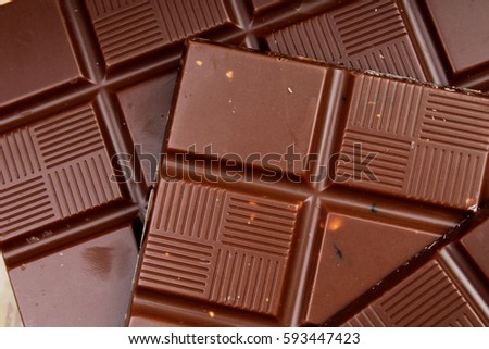 Chocolate bars as background. Milk and dark shiny chocolate texture. Stack chocolates pattern. Stunning beautiful cacao brown dessert sweets. 