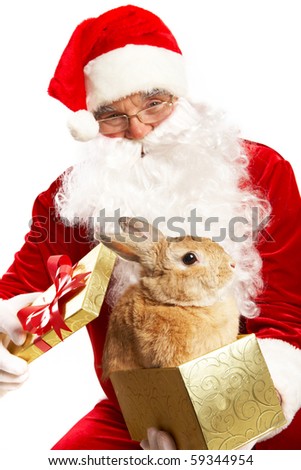 Photo of happy Santa Claus holding giftbox with cute rabbit