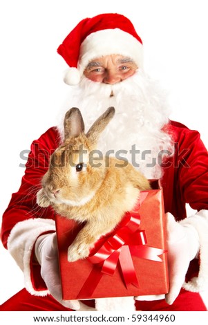 Photo of happy Santa Claus holding giftbox with cute rabbit