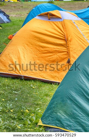 Hiking camp outdoor with tent in forest in summer, wood-side camping site, canvas town
