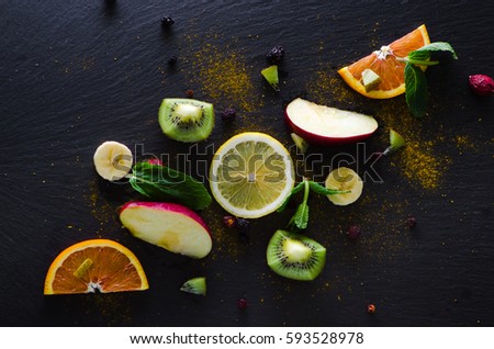 Still life of fresh fruit with spices on a black background Royalty-Free Stock Photo #593528978