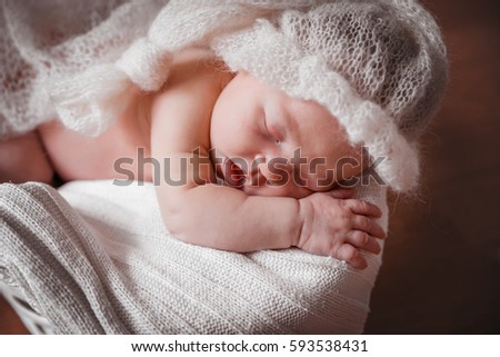 Newborn baby sleeping in soft fluffy hat.