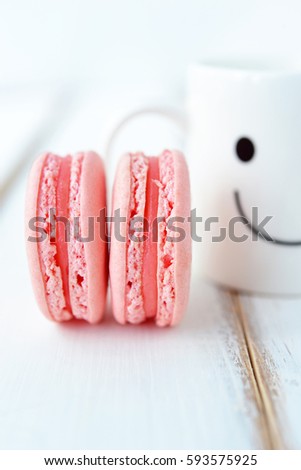 French pastel color macarons with happy cup in the background. Concept about happiness and waiting for someone. (Creative style for postcard)
