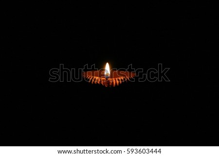 Panati, a clay oil lamp in absolute darkness. Commonly used lamp during Diwali, the festival of lights, in India. Royalty-Free Stock Photo #593603444