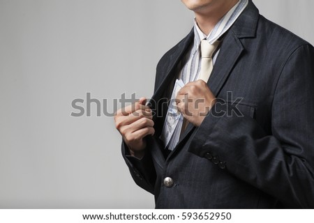 man businessman in suit taking notes, bills of dollars in his pocket as a bribe. the concept of corruption and bribery