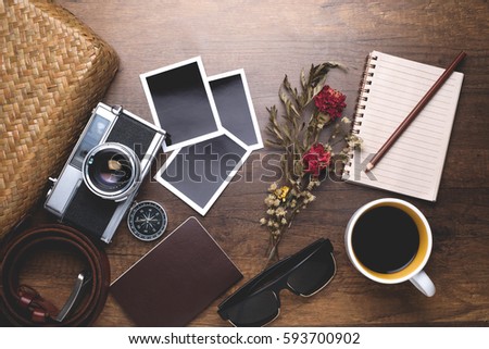 Retro camera with empty old instant paper photo album and coffee on wood background, top view (vintage style)